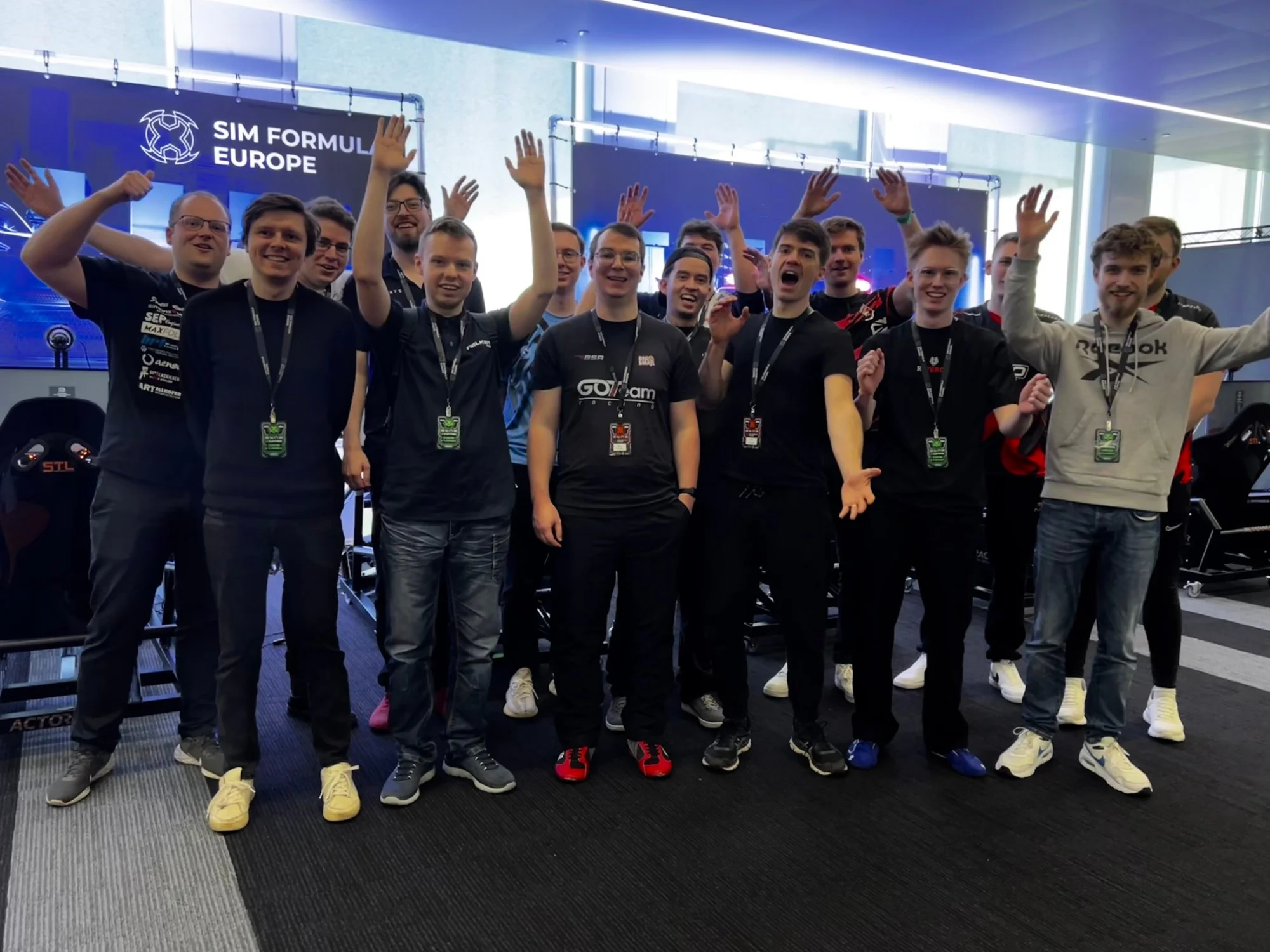 The SFE Championship finalists cheering in front of the Sim Formula Europe wall