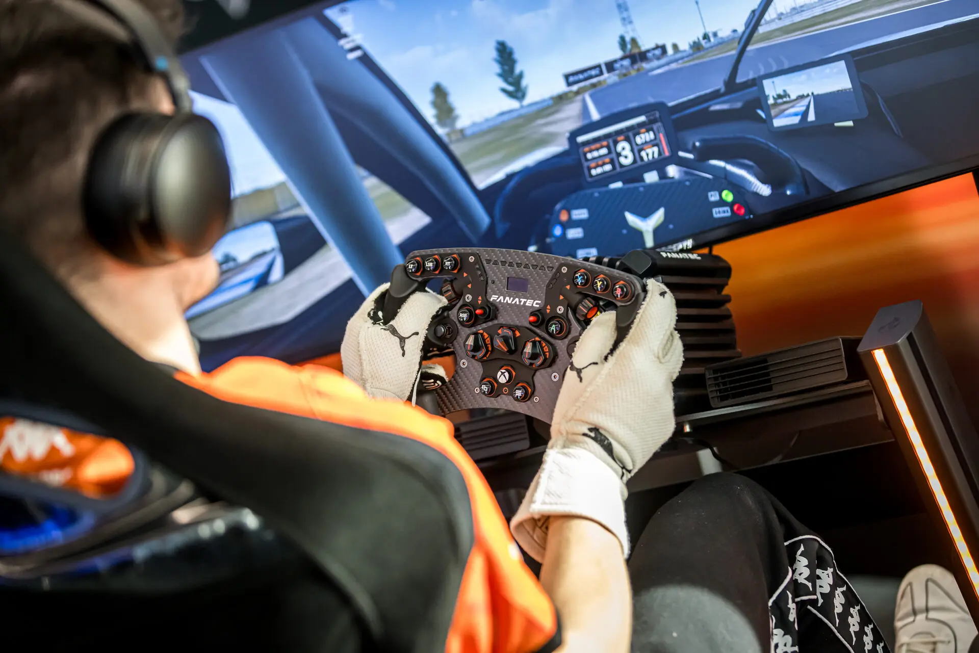 A driver with both hands on the wheel during a race